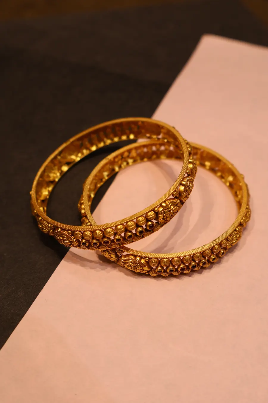 A pair of antique-finish gold bangles