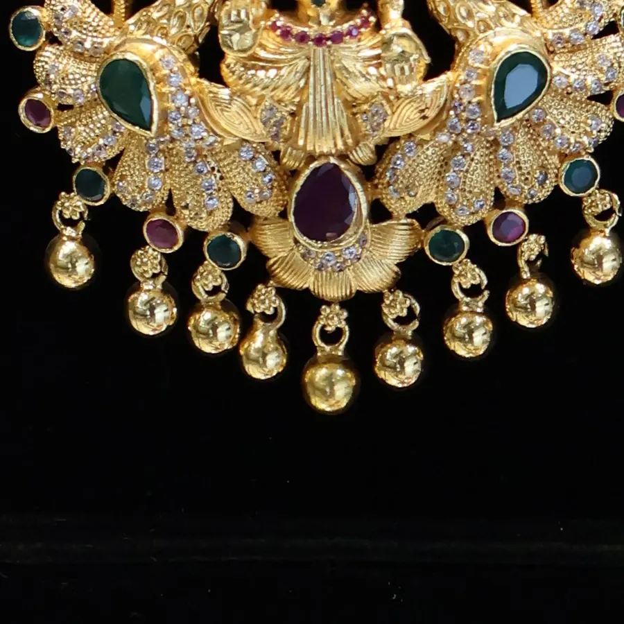 Close-up: gold bell drops under the lower pendant