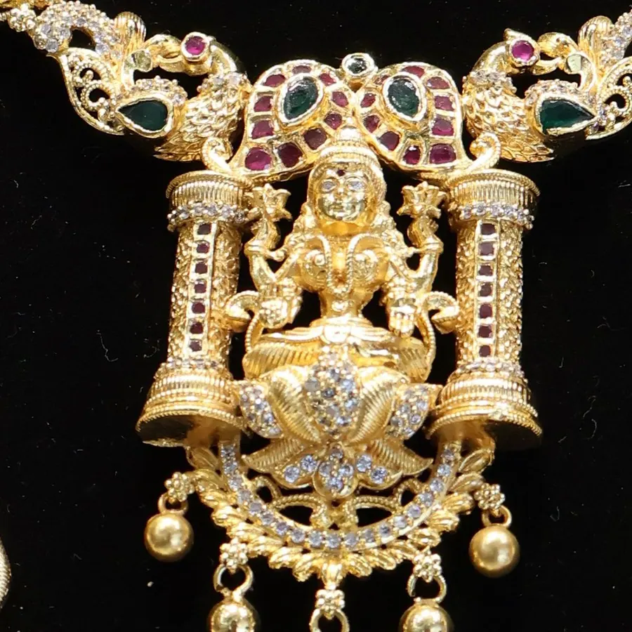 Close-up: a Lakshmi pendant set between two pillars