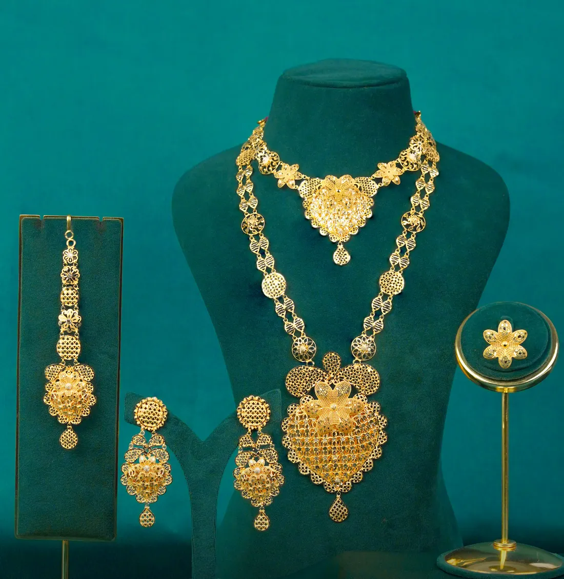 A bridal set on teal velvet: necklace, long haram, jhumkas and maang tikka