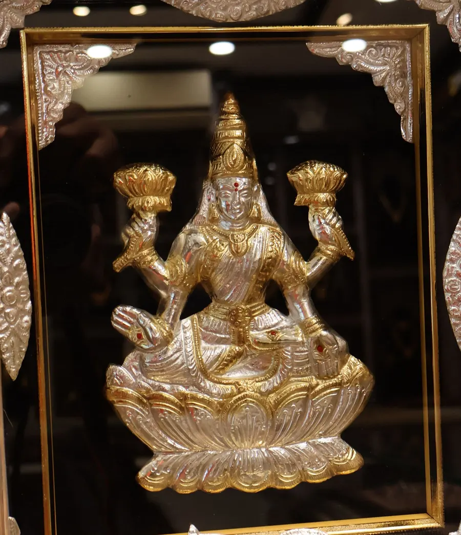 Lakshmi seated on a lotus, in silver and gold, in a frame