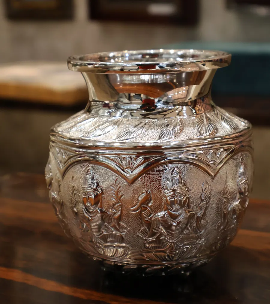 A silver kalash worked with deities in relief